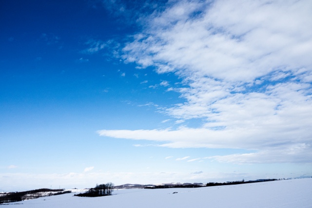 草原の雪景色と青い空と白い雲